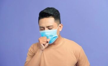 man coughing wearing mask